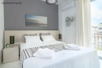 a white bedroom with two beds and a window at Apollo & Artemis by Heloni Apartments in Athens