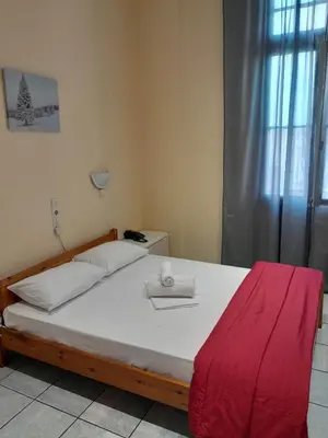 a bedroom with a large bed with a red blanket at Ikaros in Piraeus