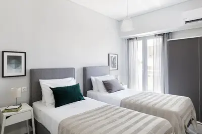 two beds in a white room with a window at Minimal 2BD Apartment with Lycabettus view by UPSTREET in Athens
