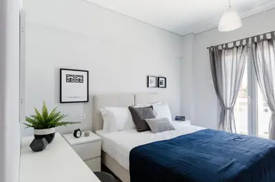 a white bedroom with a bed and a window at Minimal 2BD Apartment with Lycabettus view by UPSTREET in Athens