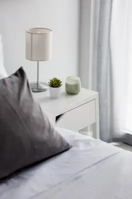a bed with a nightstand with a lamp and a table with a clock at Minimal 2BD Apartment with Lycabettus view by UPSTREET in Athens
