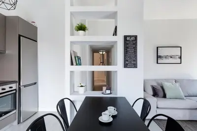 a kitchen and living room with a black table and chairs at Minimal 2BD Apartment with Lycabettus view by UPSTREET in Athens