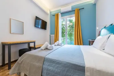 a bedroom with a bed with a desk and a window at Splash Of Glam I 10 steps from Acropolis in Athens