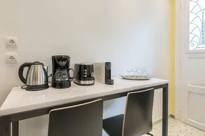 a counter with two coffee makers and wine glasses on it at Splash Of Glam I 10 steps from Acropolis in Athens