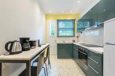 a kitchen with green cabinets and a counter top at Splash Of Glam I 10 steps from Acropolis in Athens