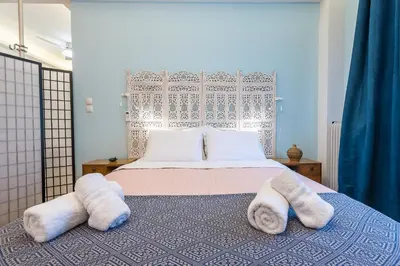 a bedroom with a bed with towels on it at Splash Of Glam I 10 steps from Acropolis in Athens