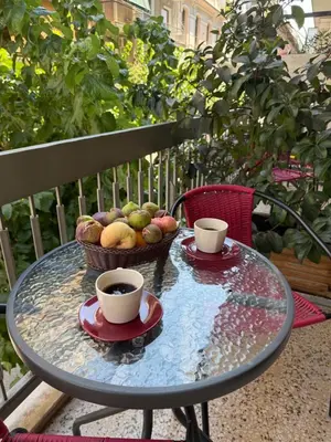 a glass table with two cups of coffee and a basket of fruit at Petaluda House 3 in Athens