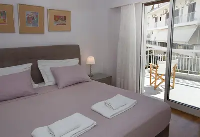 a bedroom with a bed with two towels on it at Familygroupflat in Athens