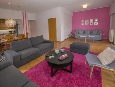 a living room with a couch and a table at Familygroupflat in Athens