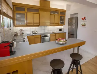 a kitchen with a counter with stools in it at Familygroupflat in Athens