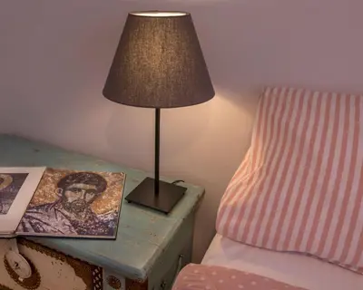 a lamp on a side table next to a bed at Familygroupflat in Athens