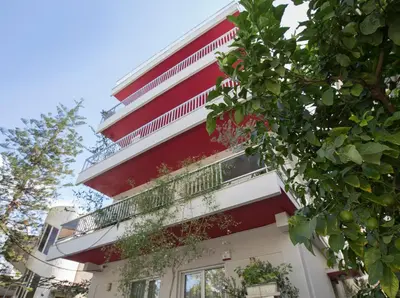 a red and white building with a balcony at Familygroupflat in Athens