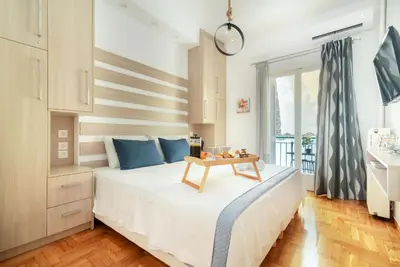 a bedroom with a bed with a table on it at Hermes by Heloni Apartments in Athens