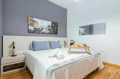 a bedroom with a bed with a table on it at Hermes by Heloni Apartments in Athens