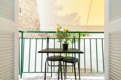 a small table with two chairs on a balcony at Hermes by Heloni Apartments in Athens