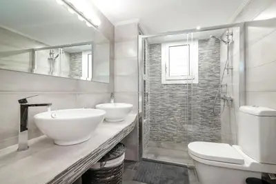 a bathroom with two sinks and a shower at Hermes by Heloni Apartments in Athens