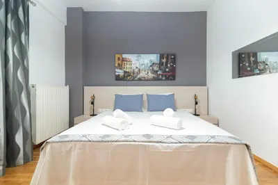 a bedroom with a large bed with two towels on it at Hermes by Heloni Apartments in Athens