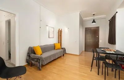 a living room with a couch and a table at Scent Of Freedom Apartment Renovated in Athens