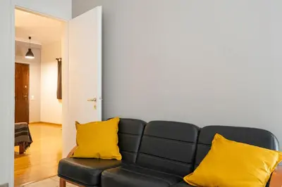 a living room with a black couch with yellow pillows at Scent Of Freedom Apartment Renovated in Athens