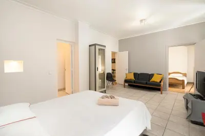 a bedroom with a white bed and a living room at Scent Of Freedom Apartment Renovated in Athens