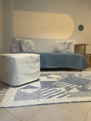 a bedroom with a bed and a rug with a blue mattress at cozy minimal apartment in Piraeus