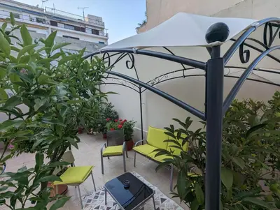 a patio with green chairs and an umbrella at cozy minimal apartment in Piraeus