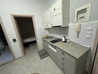 a kitchen with white cabinets and a sink and a phone at cozy minimal apartment in Piraeus