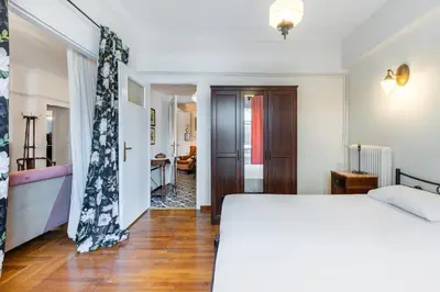 a bedroom with a white bed and a hallway at Athens Parrot in Athens