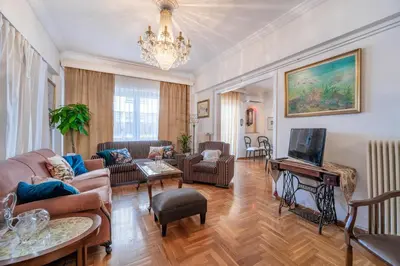 a living room with furniture and a chandelier at Athens Parrot in Athens