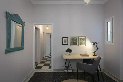 a hallway with a desk with a chair and a window at Absolute Athens Apartments in Athens
