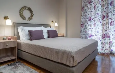 a bedroom with a large bed with purple pillows at Absolute Athens Apartments in Athens