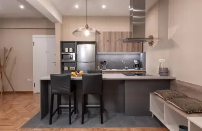 a kitchen with a black island with bar stools at Absolute Athens Apartments in Athens