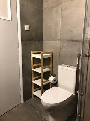 a bathroom with a toilet and a wooden shelf at Acropolis View Penthouse N in Athens