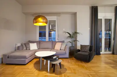 a living room with a couch and a table and chairs at Acropolis View Penthouse N in Athens