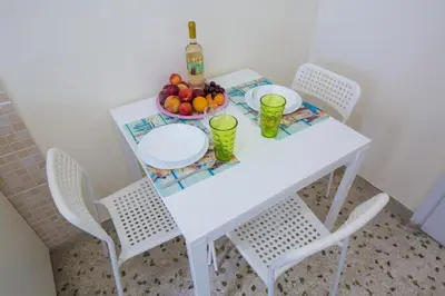 a white table with two chairs and a bowl of fruit at VIP Greece Petros in Athens