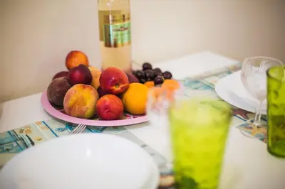 a plate of fruit on a table with a drink at VIP Greece Petros in Athens