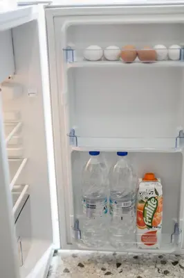 an open refrigerator with bottles of water and milk at VIP Greece Petros in Athens