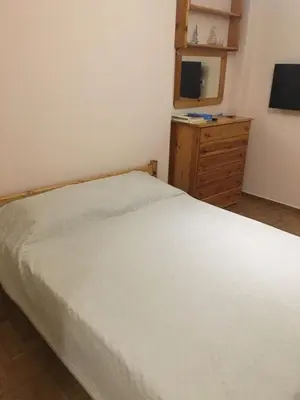 a bedroom with a bed and a dresser and a television at VIP Greece Petros in Athens