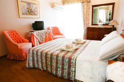 a bedroom with a bed and a chair and a mirror at Astonishing view in Athens