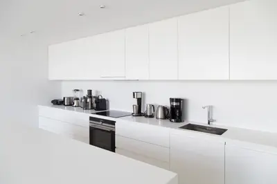 a kitchen with white cabinets and black appliances at The Margi Villa in Athens