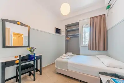 a bedroom with a bed and a desk and a mirror at Phaedra Hotel in Athens
