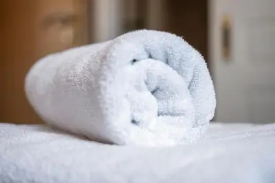 a roll of white towels sitting on top of a bed at Phaedra Hotel in Athens