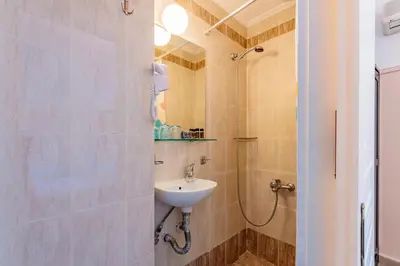 a bathroom with a sink and a shower at Phaedra Hotel in Athens