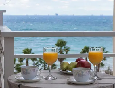 a table with two glasses of orange juice and fruit at Edem BeachFront SeaView Dream Home In Beautiful Athens Riviera in Palaio Faliro in Athens