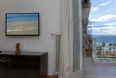 a living room with a flat screen tv on a wall at Edem BeachFront SeaView Dream Home In Beautiful Athens Riviera in Palaio Faliro in Athens