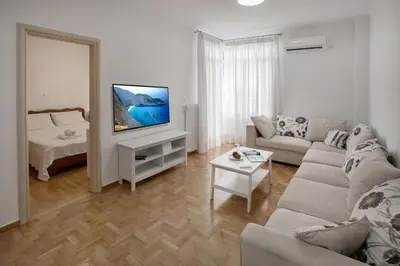 a living room with a couch and a tv at Edem BeachFront SeaView Dream Home In Beautiful Athens Riviera in Palaio Faliro in Athens