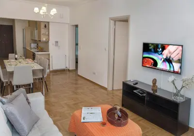 a living room with a couch and a tv on a wall at Edem BeachFront SeaView Dream Home In Beautiful Athens Riviera in Palaio Faliro in Athens