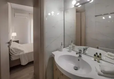 a bathroom with a sink and a mirror and a bed at Edem BeachFront SeaView Dream Home In Beautiful Athens Riviera in Palaio Faliro in Athens