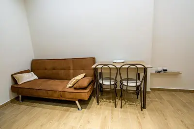 a living room with a couch and a table with chairs at Sweet Home VIPGreece in Athens