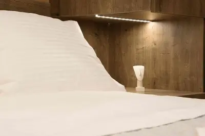 a bedroom with a white bed and a wooden wall at Electra & Myrto Apartments in Athens